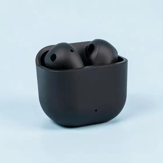 Matte black wireless earbuds in a charging case on a pale blue backdrop